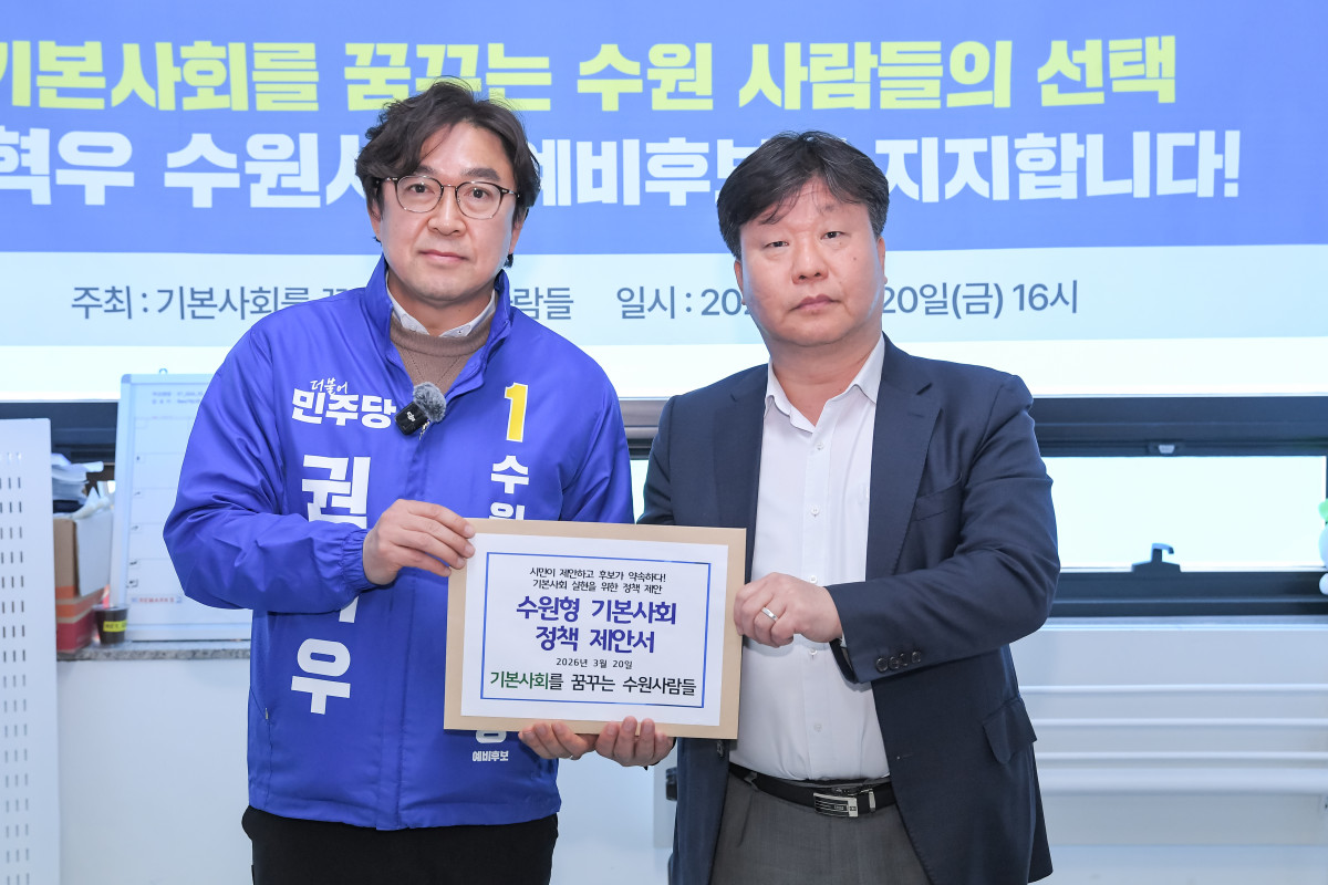 ▲권혁우 수원시장 예비후보(왼쪽)가 20일 '기본사회를 꿈꾸는 수원 사람들' 관계자로부터 수원형 기본사회 정책 제안서를 전달받고 있다. (권혁우 예비후보 캠프)