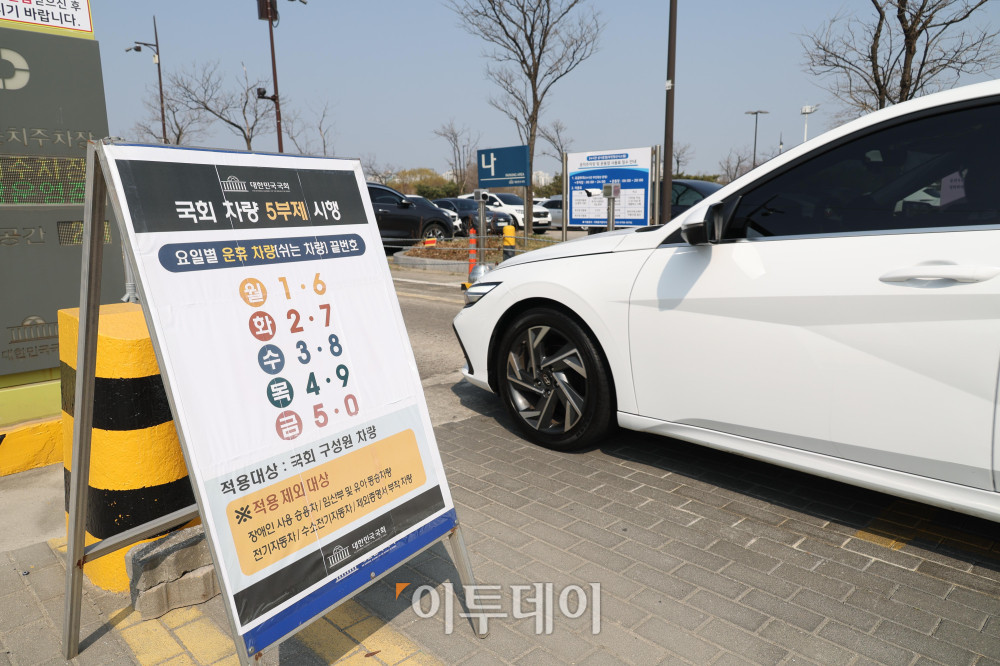▲공공부문 차량 5부제 강화 시행 첫날인 25일 서울 여의도 국회 둔치주차장에 차량 5부제 안내문이 세워져 있다. 이번 조치는 정부가 원유 관련 자원안보 위기 경보를 '주의' 단계로 격상한 데 따른 에너지 수급 대응의 일환으로, 경차와 하이브리드차 등 기존 제외 차량도 적용 대상에 포함됐다. 고이란 기자 photoeran@