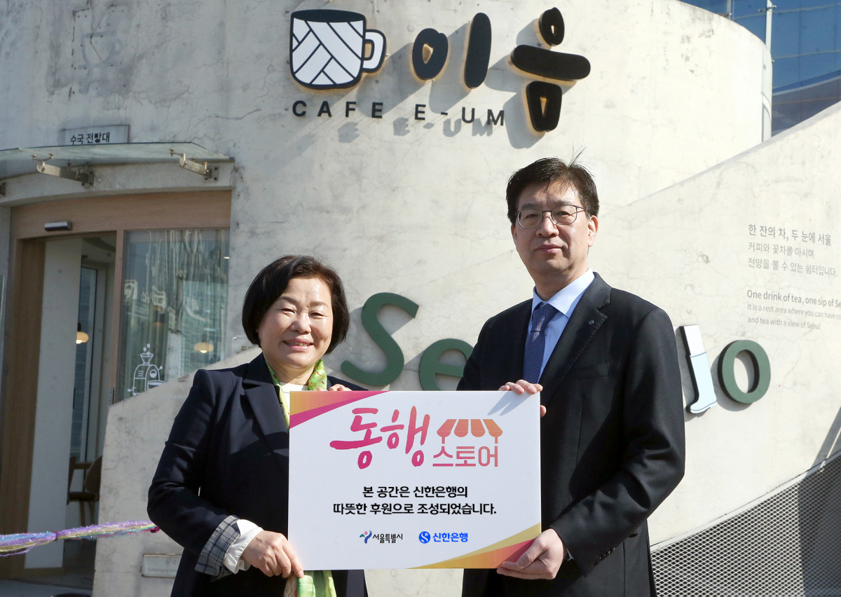 ▲강영홍(사진 오른쪽) 신한은행 경영지원그룹장과 서정화 열린여성센터 원장이 25일 서울로7017에서 진행한 ‘동행스토어’ 3호점 ‘카페 이음’ 개점식에서 기념촬영하고 있다. (사진제공=신한은행)