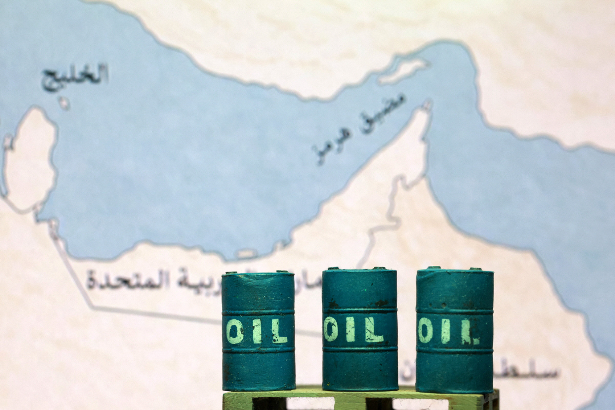 ▲석유 드럼통 너머로 호르무즈 해협 지도가 보인다. 로이터연합뉴스