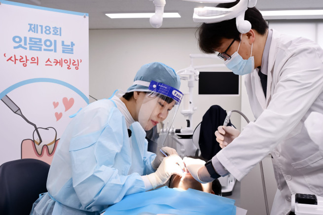 ▲사랑의 스케일링 홍보대사로 위촉된 전현희 국회의원이 의료 전문가로서 진료복을 입고 직접 스케일링 봉사활동에 동참하고 있다. (사진제공=동국제약)