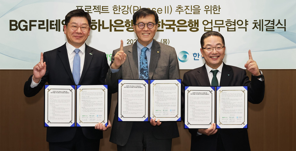 ▲이호성 하나은행장(사진 오른쪽)이 이창용 한국은행 총재(가운데), 민승배 BGF리테일 대표이사(왼쪽)와 함께 협약서를 들고 기념촬영을 하고 있다. (하나은행)