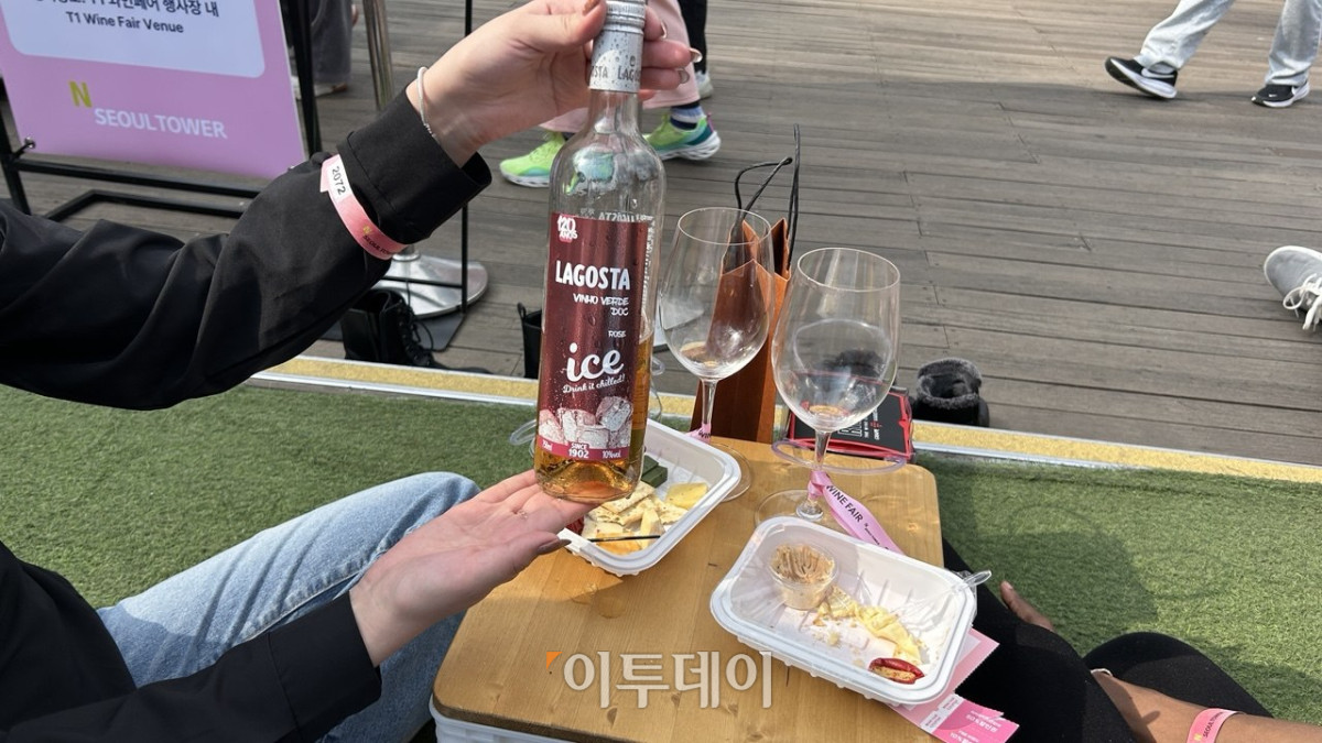 ▲4일 서울 용산구 N 서울타워에서 진행된 '2026 남산 와인페어'에서 외국인 방문객들이 구입한 와인을 소개하고 있다. (사진=연희진 기자)