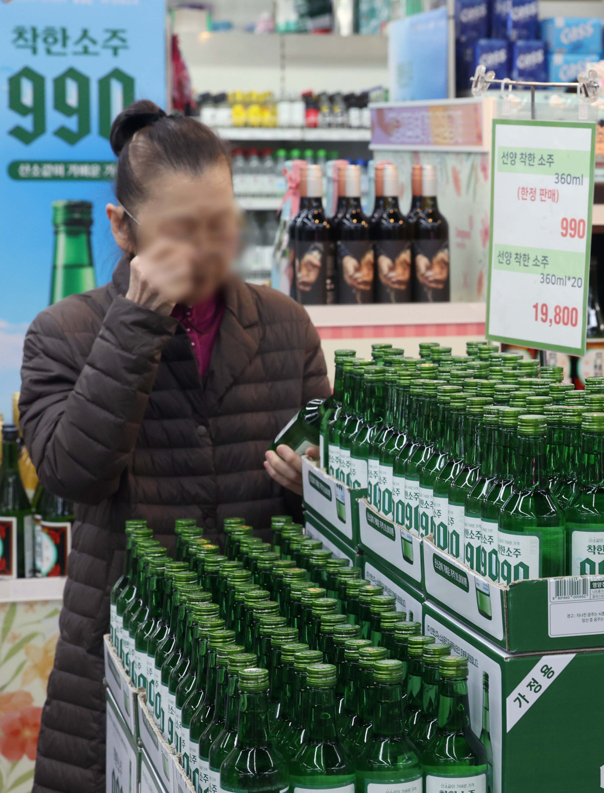 ▲6일 서울 송파구 가락몰 다농마트에서 시민들이 선양소주의 ‘착한소주 990’을 살펴보고 있다. 360mL용량에 알코올 도수16도인 ‘착한소주 990’은 조웅래 선양소주 회장이 직접 광고 모델로 참여, 마케팅 비용을 줄이고 이를 가격인하에 반영해 출시된 동네슈퍼 전용 상품이다. 소비자 가격은 병당 990원, 한 박스(20병) 기준 1만9800원이다. 신태현 기자 holjjak@