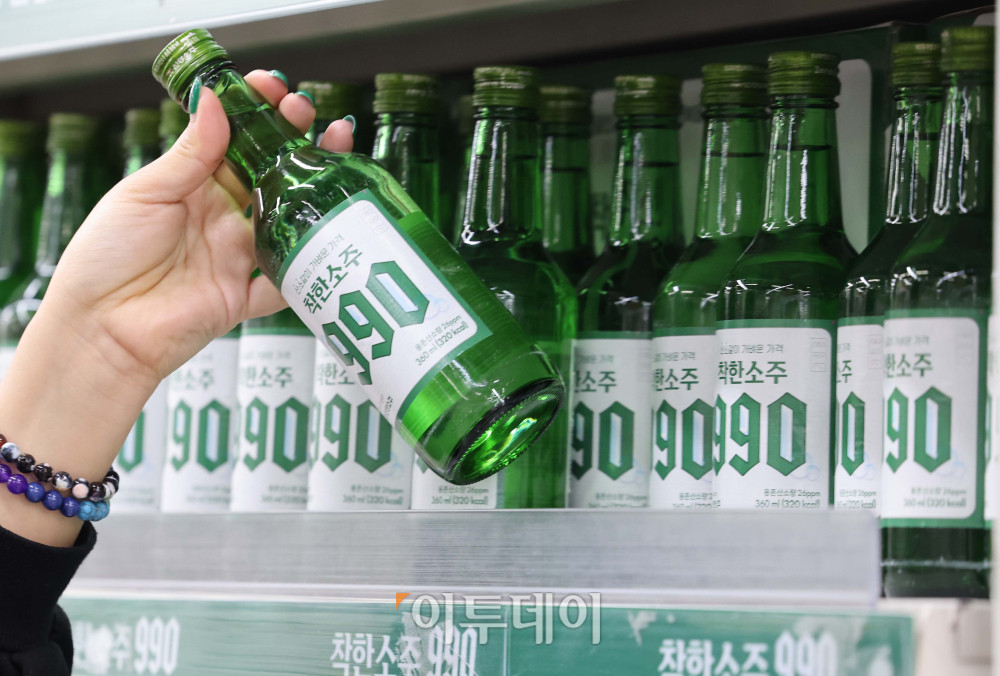▲6일 서울 송파구 가락몰 다농마트에서 시민들이 진열된 '착한소주 990'을 살펴보고 있다. 360ml 용량에 알코올 도수 16도인 '착한소주 990'은 조웅래 선양소주 회장이 직접 광고 모델로 참여해 마케팅 비용을 줄이고, 이를 가격 인하에 반영해 출시된 동네슈퍼 전용 상품이다. 소비자 가격은 병당 990원, 한 박스(20병) 기준 1만 9800원이다.