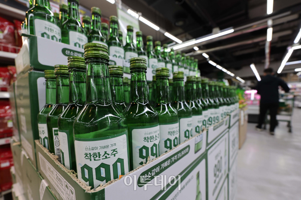 ▲6일 서울 송파구 가락몰 다농마트에서 시민들이 진열된 '착한소주 990'을 살펴보고 있다. 360ml 용량에 알코올 도수 16도인 '착한소주 990'은 조웅래 선양소주 회장이 직접 광고 모델로 참여해 마케팅 비용을 줄이고, 이를 가격 인하에 반영해 출시된 동네슈퍼 전용 상품이다. 소비자 가격은 병당 990원, 한 박스(20병) 기준 1만 9800원이다.