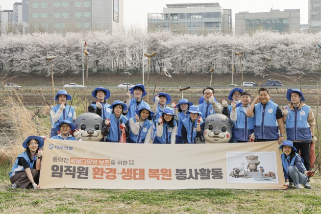 ▲대우건설 임직원들이 중랑천에서 봉사활동을 진행 후 기념 촬영을 하고 있다. (사진제공=대우건설)