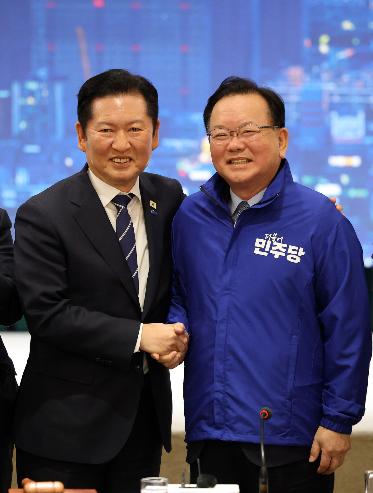 ▲더불어민주당 정청래 대표가 8일 대구 북구 인터불고 엑스코 호텔에서 열린 더불어민주당 현장 최고위원회의에서 대구시장 후보인 김부겸 전 국무총리에게 당 점퍼를 입혀준 뒤 기념 촬영을 하고 있다. (사진=연합뉴스)
