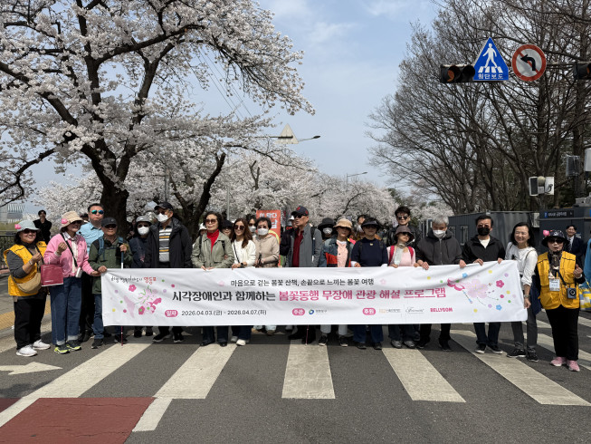 ▲‘시각장애인과 함께하는 봄꽃 동행 무장애 관광 프로그램’ 참가자들이 행사 현수막을 들고 단체 기념 촬영을 하고 있다. (사진제공=서울관광재단)