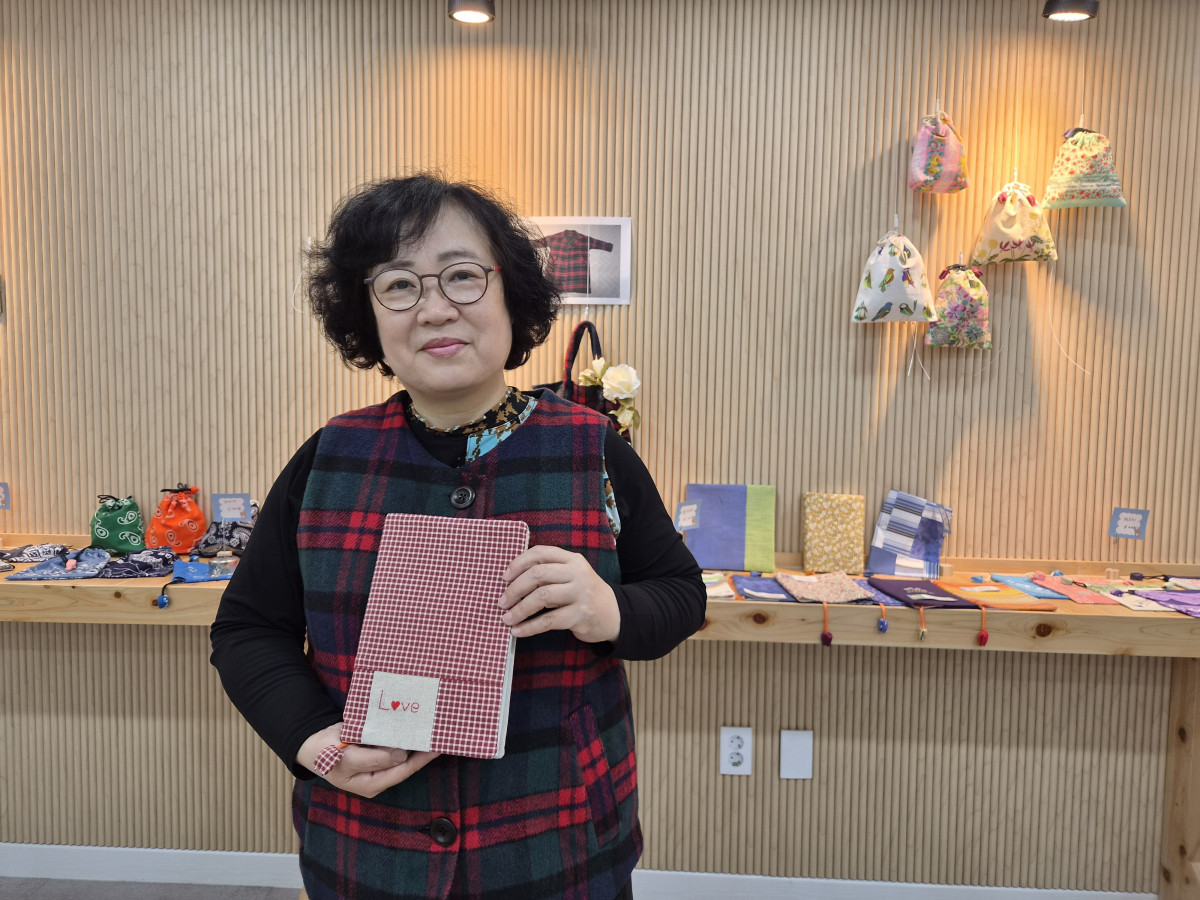 ▲코트를 리폼한 조끼와 천조각을 모아 만든 북커버를 소개하는 박경희 작가.(윤나래 기자)