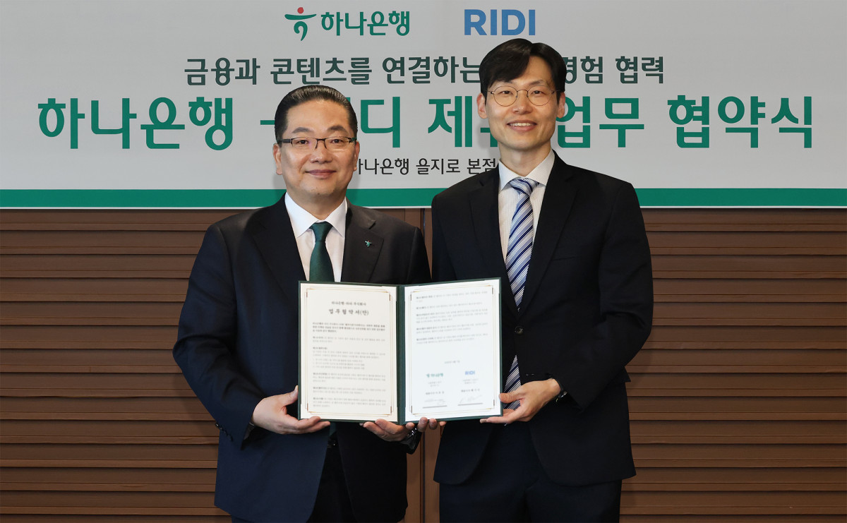 ▲이호성(사진 왼쪽) 하나은행장은 배기식 리디 대표이사과 함께 협약서를 들고 기념촬영을 하고 있다. (사진제공=하나은행)