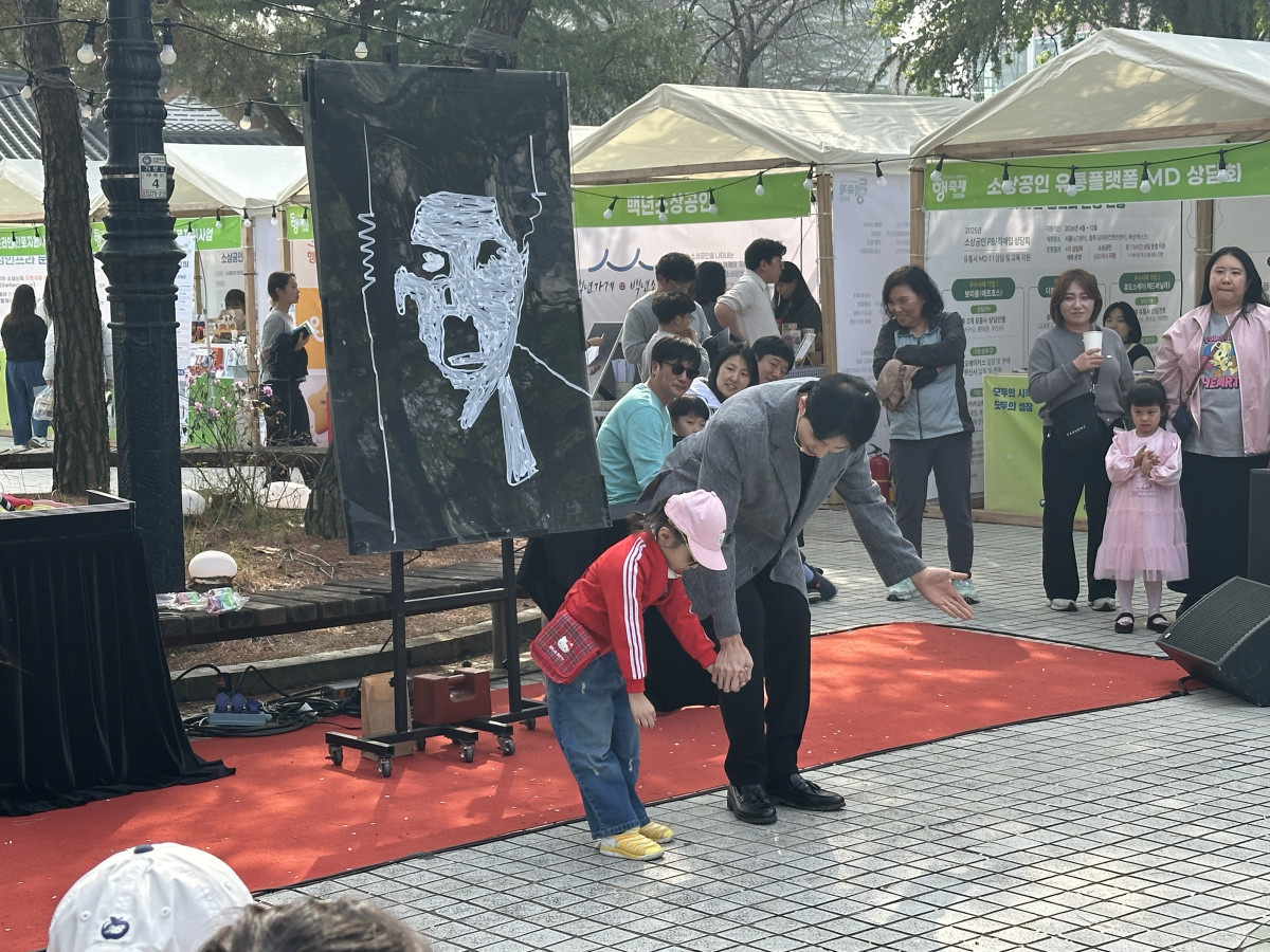 ▲11일 ‘4월 동행축제’가 진행된 전북 전주시 전북대학교 알림의거리에서 행사 관계자가 시민과 마술 공연을 선보이고 있다. (서이원 기자 @iwonseo96)
