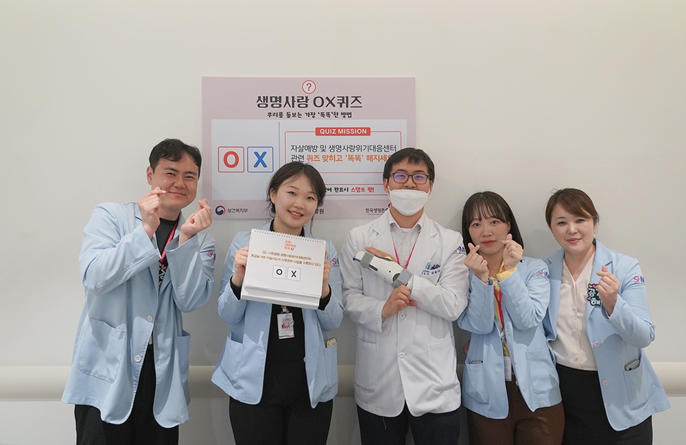 ▲김용기 시화병원 생명사랑위기대응센터 부센터장(가운데)과 센터 직원들이 15일 본관 지하 1층에서 열린 '제1회 생명사랑위기대응센터 캠페인' 현장에서 OX퀴즈 부스를 운영하며 직원들의 정신건강 증진 활동을 이끌고 있다. (시화병원)