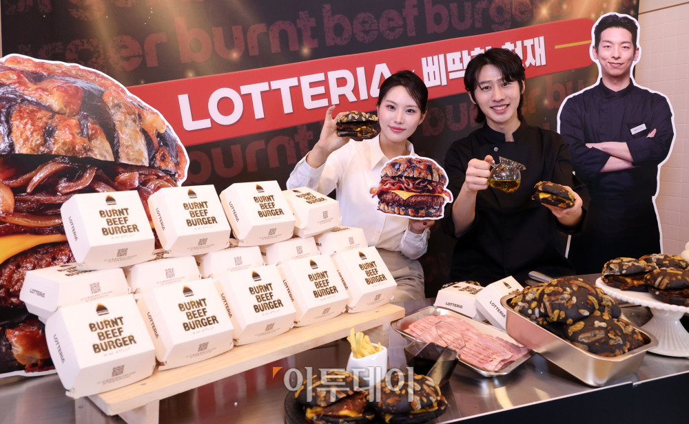 ▲롯데리아에서 타기 직전까지 끌어올린 재료 본연의 풍미를 담은 새로운 컨셉의 비프버거가 출시됐다. 롯데리아는 TTF(Taste The Fun)의 콘셉트 아래 '삐딱한 천재' 이찬양 셰프와의 협업을 통해 남다른 시선으로 바라본 삐탁한 버거 '번트 비프버거'를 선보인다. 번트 비프버거는 마치 그을린듯한 특이한 형상의 번트치즈번과 함께 캐러멜어니언과 깊은 육향의 순비프패티로 제품의 맛을 배가시킨 독특한 제품이다. 17일 롯데리아 숙대입구역점에서 모델들이 신제품 번트 비프버거를 소개하고 있다. 고이란 기자 photoeran@