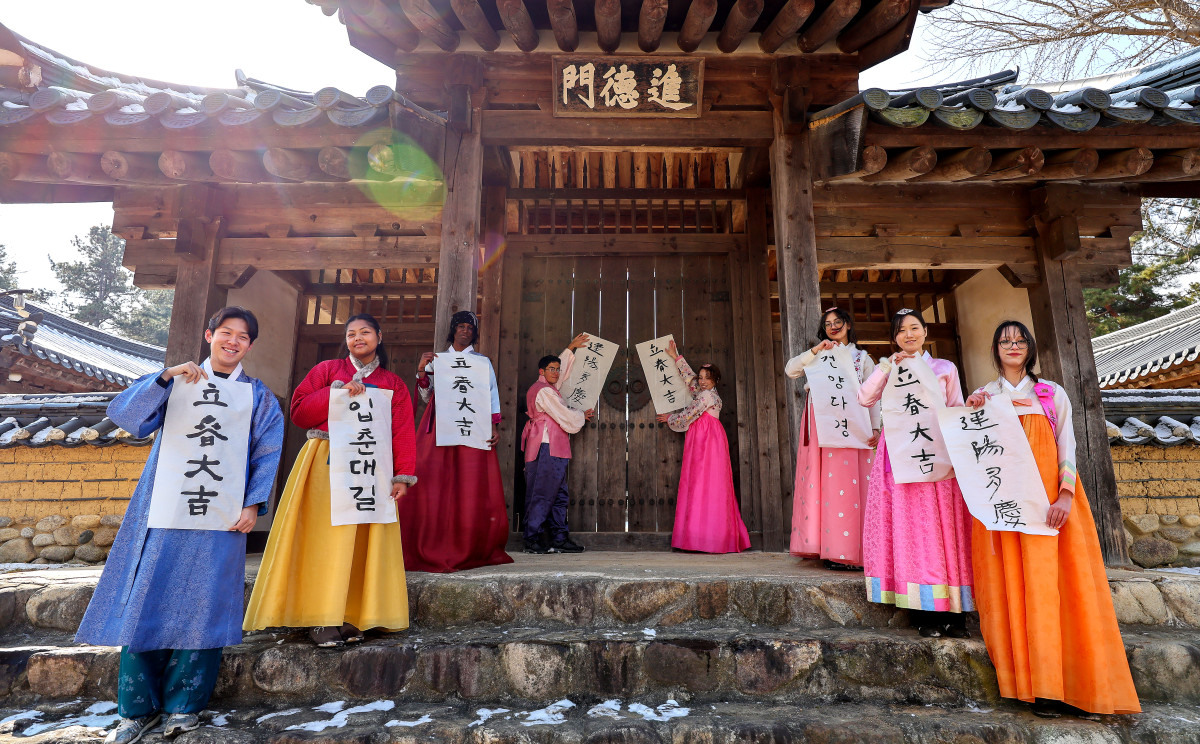 ▲2월  2일 경북 경산시 영남대학교 민속촌에서 한국 전통문화 체험에 참여한 외국인 유학생들이 ‘입춘대길' ‘건양다경' 등이 적힌 입춘첩을 구계서원 진덕문에 붙이고 있다. (뉴시스)