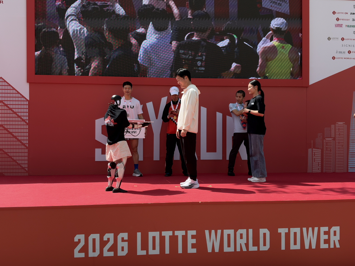 ▲19일 서울 잠실에서 열린 ‘2026 롯데월드타워 스카이런(SKY RUN)’ 엘리트부문 시상자로 오른 롯데이노베이트 휴머노이드로봇(왼쪽). 사진=황민주 기자