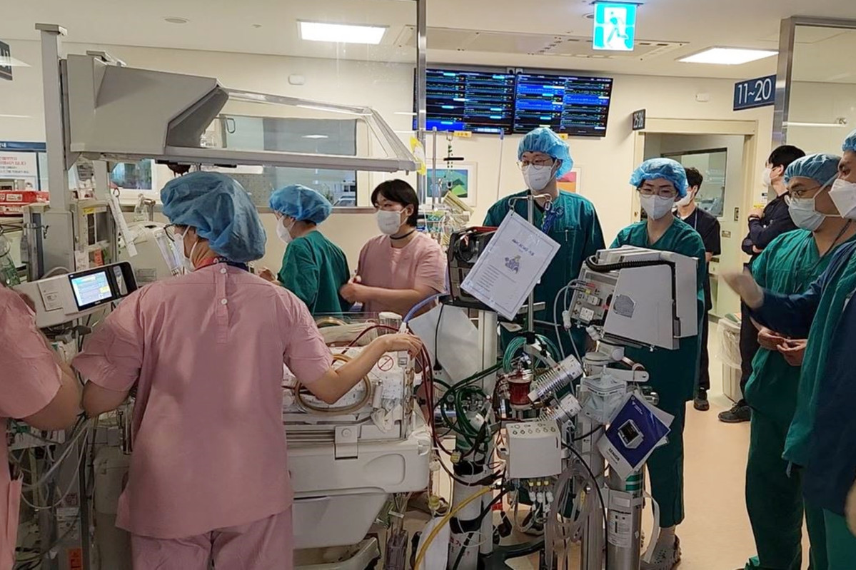 ▲서울아산병원에서 신생아과 의사와 간호사, 인공심폐기사 등 10명 이상의 의료진이 투입돼 에크모 기계와 인공호흡기를 연결한 신생아 환자를 수술장으로 이동하고 있다. (사진제공=서울아산병원)