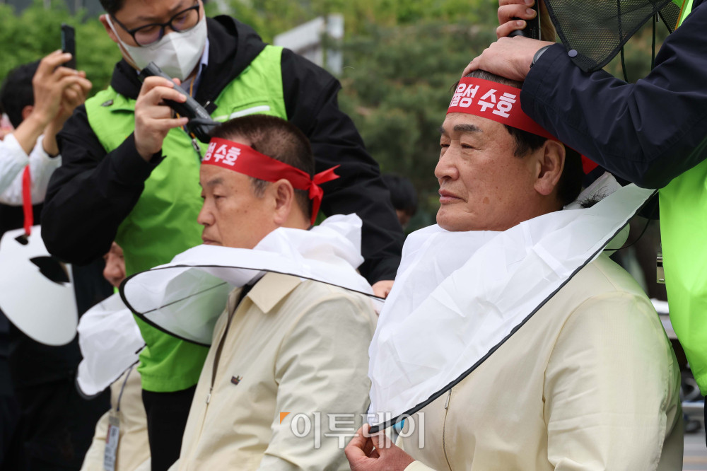 ▲21일 서울 여의도공원 인근에서 열린 농협 자율성 수호 농민 결의대회에서 참석자들이 정부의 농협법 개정안에 반대하는 삭발식을 하고 있다. 고이란 기자 photoeran@