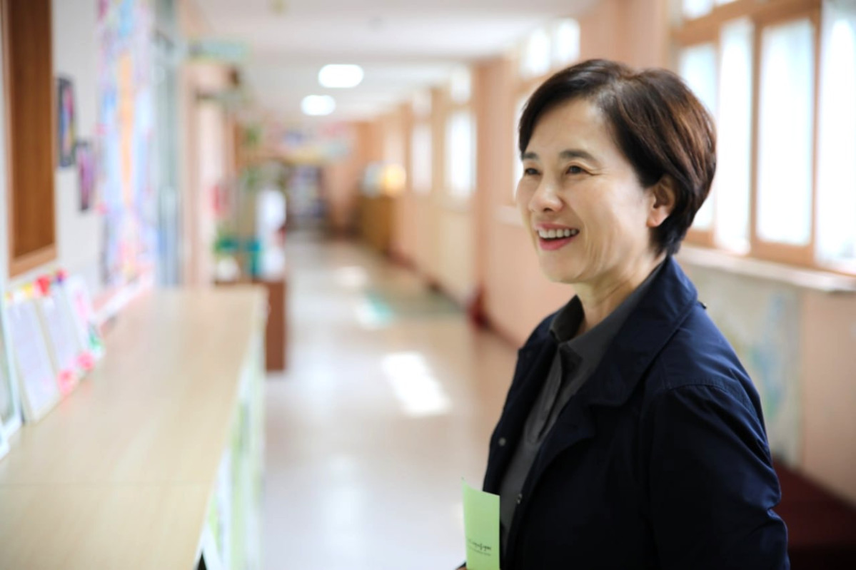 ▲유은혜 경기도교육감 예비후보가 21일 수원시립서호지역아동센터를 방문한 뒤 학교 복도에서 아동들의 작품을 바라보며 미소 짓고 있다. 단일화 경선 마지막 공식 일정이었다. (유은혜 예비후보 캠프)