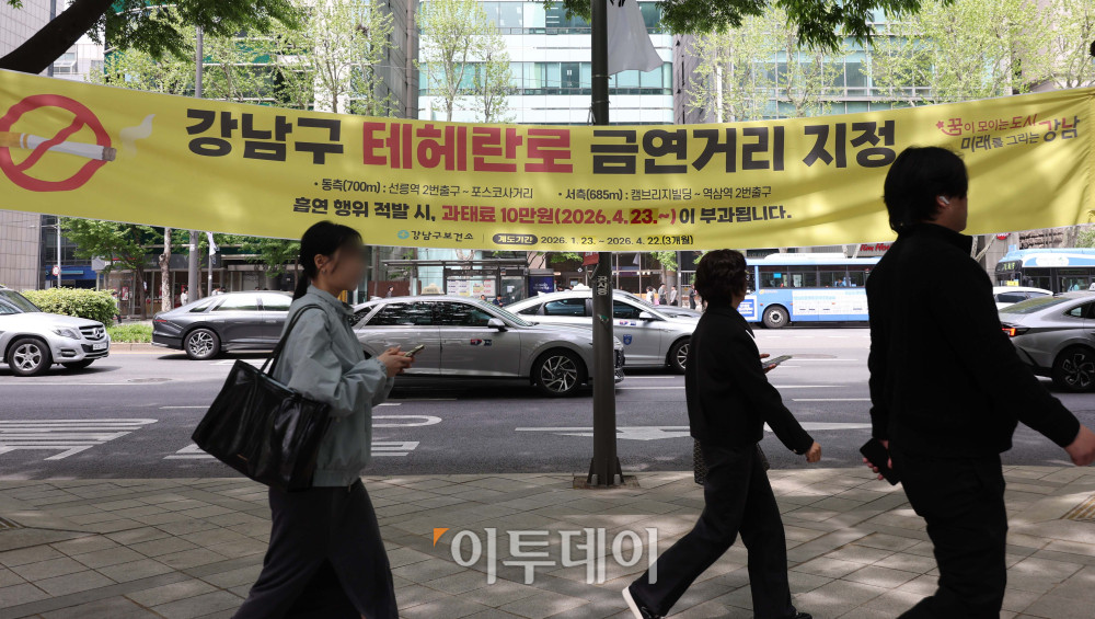 ▲서울 강남구 테헤란로 금연거리 지정을 하루 앞둔 22일 시민들이 관련 안내문 옆으로 걸어가고 있다. 기존 담배는 물론 합성 니코틴 전자담배도 단속 대상에 포함되며, 위반 시 최대 10만원의 과태료과 부과된다. 김예연 인턴기자 kimye@