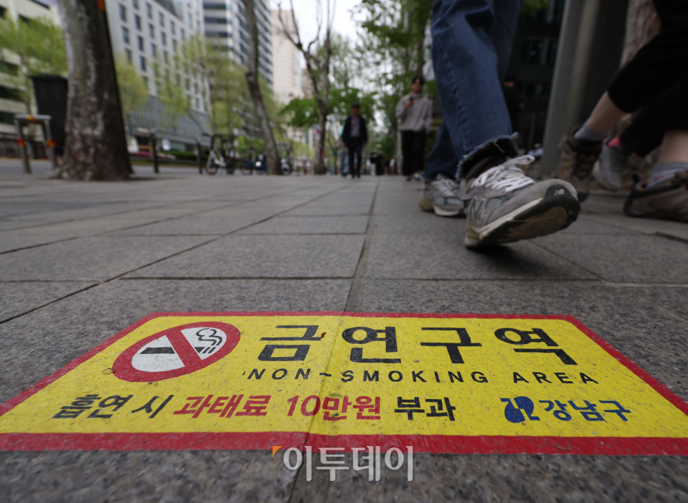 ▲서울 강남구 테헤란로 금연거리 지정을 하루 앞둔 22일 시민들이 관련 안내문 옆으로 걸어가고 있다. 기존 담배는 물론 합성 니코틴 전자담배도 단속 대상에 포함되며, 위반 시 최대 10만원의 과태료과 부과된다. 김예연 인턴기자 kimye@
