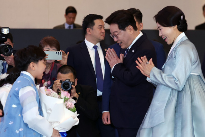 ▲베트남을 국빈 방문 중인 이재명 대통령과 김혜경 여사가 22일(현지시간) 하노이의 한 호텔에서 열린 동포간담회에서 화동과 인사하고 있다. (연합뉴스)