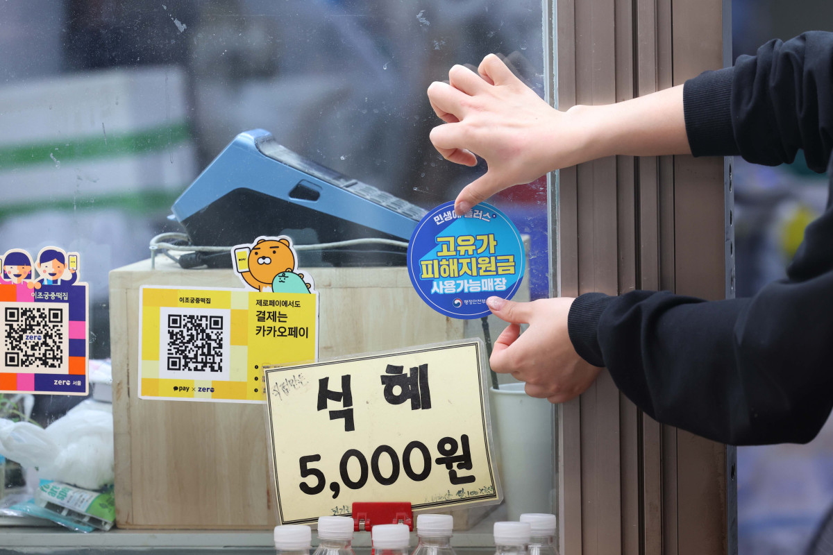 ▲국제 유가 상승에 다른 최대 60만원의 고유가 피해지원금 지급이 시작된 27일 서울 강서구 남부골목시장에서 한 상인이 고유가 지원금 사용가능 안내스티커를 부착하고 있다. 각 지자체는 전담 창구를 마련해 이날부터 내달 8일까지 1차 지급에 나선다. 지원 금액은 기초생활수급자 1인당 55만원, 차상위계층·한부모가족은 1인당 45만원이다. 비수도권과 인구감소지역 거주자는 1인당 5만원이 추가돼 최대 60만원까지 받을 수 있다. 일반 국민 대상 2차 지급은 5월 18일부터 7월 3일까지 진행될 예정이며, 수도권 10만원, 비수도권 15만원, 인구감소 우대지역 20만원, 인구감소 특별지역은 최대 25만원까지 지원된다. 지원금은 주소지 관할 지자체 내 연 매출 30억원 이하 지역화폐 가맹점에서 사용할 수 있다. 신태현 기자 holjjak@