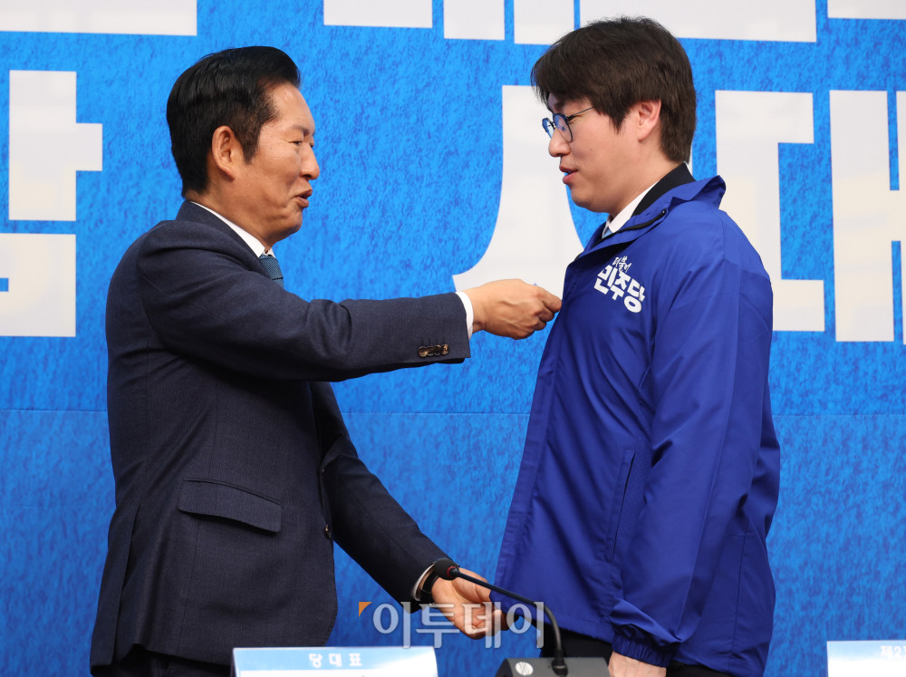 ▲하정우(오른쪽) 전 청와대 AI수석이 29일 서울 여의도 국회에서 열린 민주당 인재영입식에서 정청래 당대표에게 파란 점퍼를 받고 있다. 고이란 기자 photoeran@