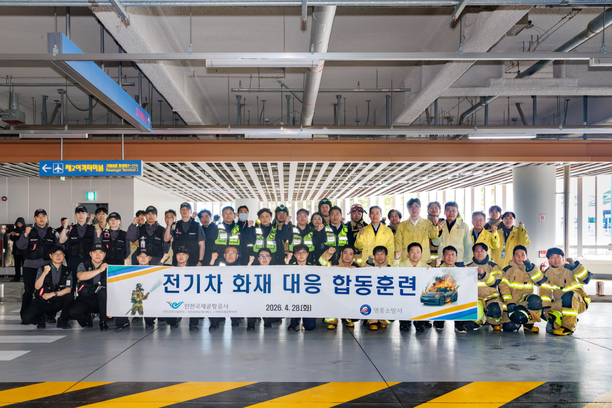 ▲인천공항 제2여객터미널 단기주차장에서 진행된 ‘전기차 화재 대응 합동훈련’에서 공항소방대, 영종소방서 등 훈련 참여자들이 기념 촬영을 하고 있다. (사진제공=인천국제공항공사)