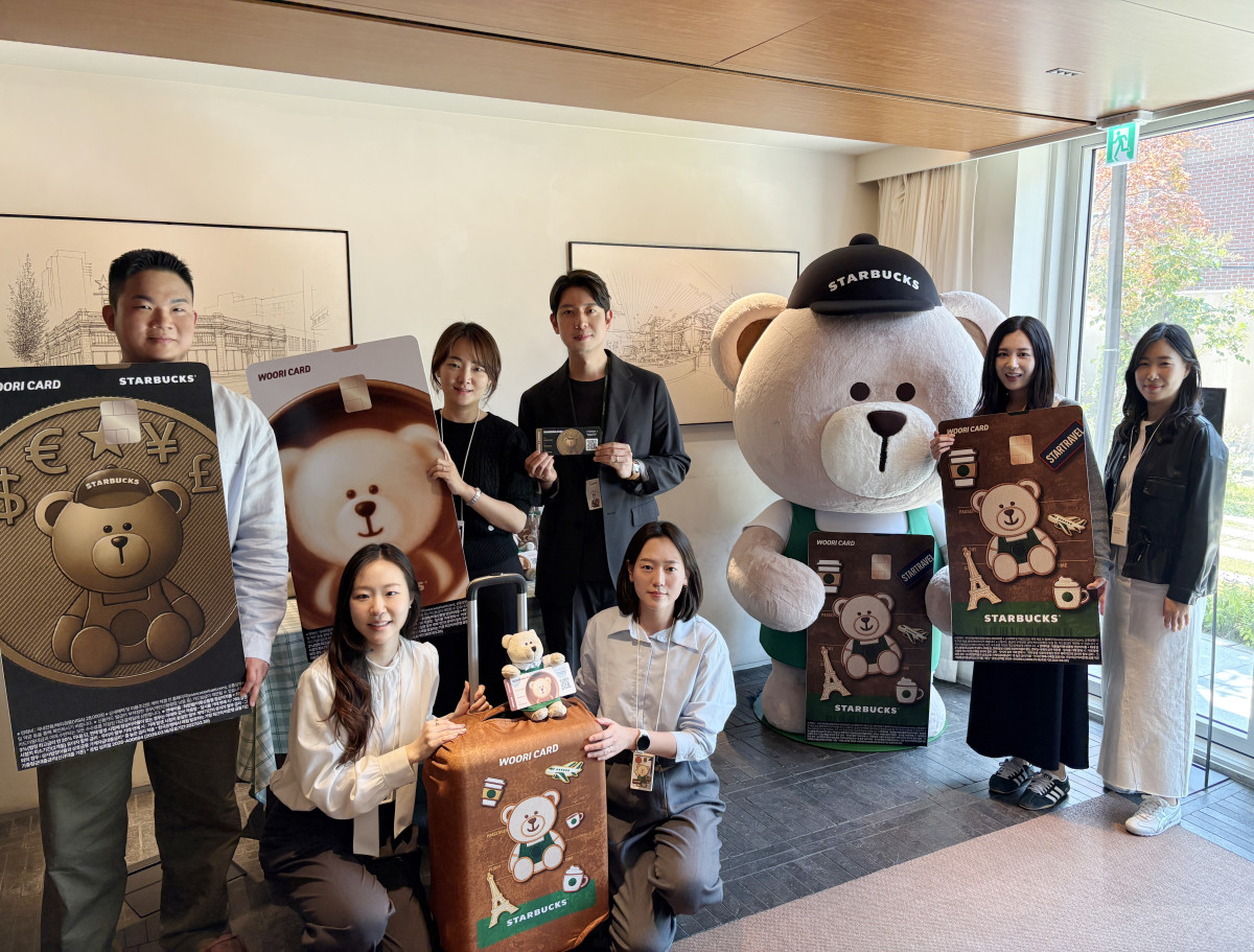 ▲‘스타트래블 우리카드’ 포토존 이벤트가 진행 중인 스타벅스 장충라운지R점에서 우리카드 및 스타벅스 관계자들이 지난달 30일 기념 사진을 촬영하고 있다 (사진제공 = 우리카드)