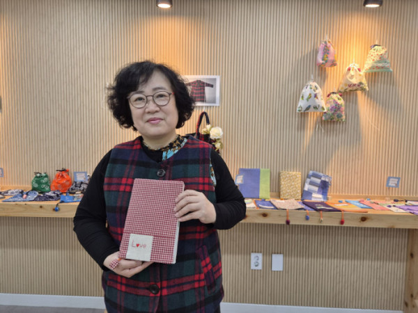 ▲코트를 리폼한 조끼와 천조각을 모아 만든 북커버를 소개하는 박경희 작가.(윤나래 기자)