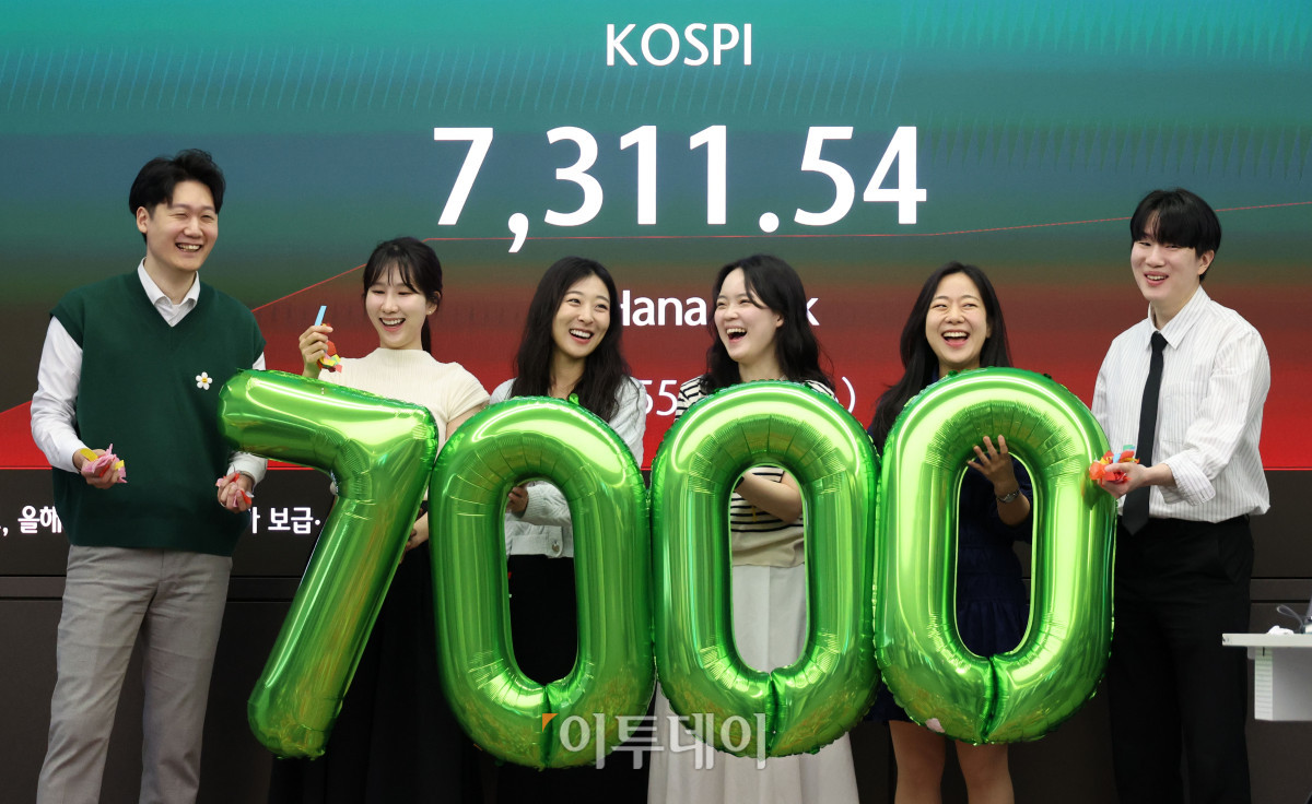 ▲코스피 지수가 7000선을 돌파한 6일 서울 중구 하나은행 딜링룸 전광판 앞에서 딜러들이 축하 세리머니를 하고 있다. 고이란 기자 photoeran@