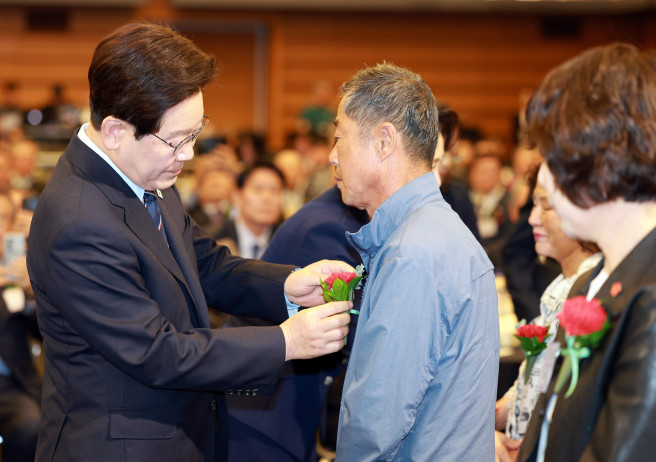 ▲이재명 대통령이 8일 서울 중구 대한상공회의소에서 열린 어버이날 기념식에서 순직 소방관, 경찰관 부모님들에게 카네이션을 달아드리고 있다. (연합뉴스)