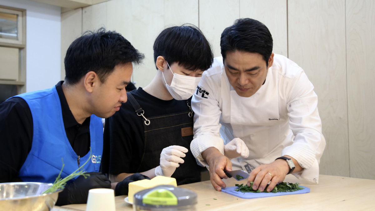 ▲타미 리 셰프가 밀알학교에서 학생들, GS리테일 임직원들과 요리 봉사 활동을 진행하고 있다. (사진제공=GS리테일)