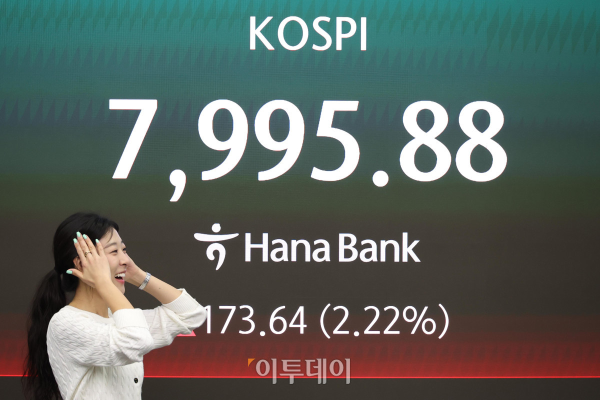 ▲코스피 지수가 장중 7900선을 첫 돌파한 12일 서울 중구 하나은행 딜링룸 전광판 앞에서 딜러가 미소를 짓고 있다. 고이란 기자 photoeran@