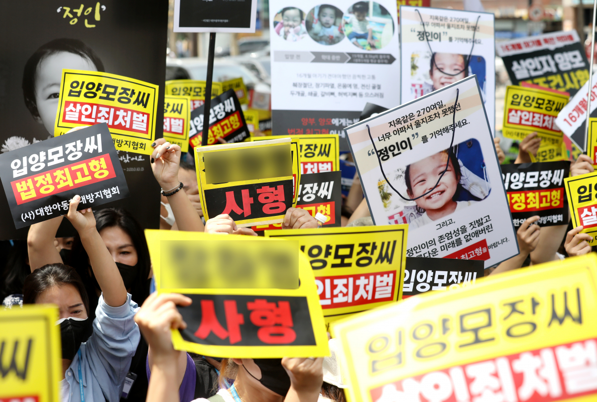 ▲2021년 당시 정인이 양부모의 1심 선고 공판을 앞두고 양모가 탑승한 호송차를 향해 손피켓을 들고 항의하는 모습. (뉴시스)