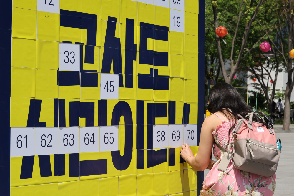 ▲스승의날을 하루 앞둔 14일 서울 종로구 광화문광장에서 열린 '교사 시민권 회복 행사'에서 한 시민이 '교사도 시민이다' 퍼즐 맞추기에 참여하고 있다. (연합뉴스)