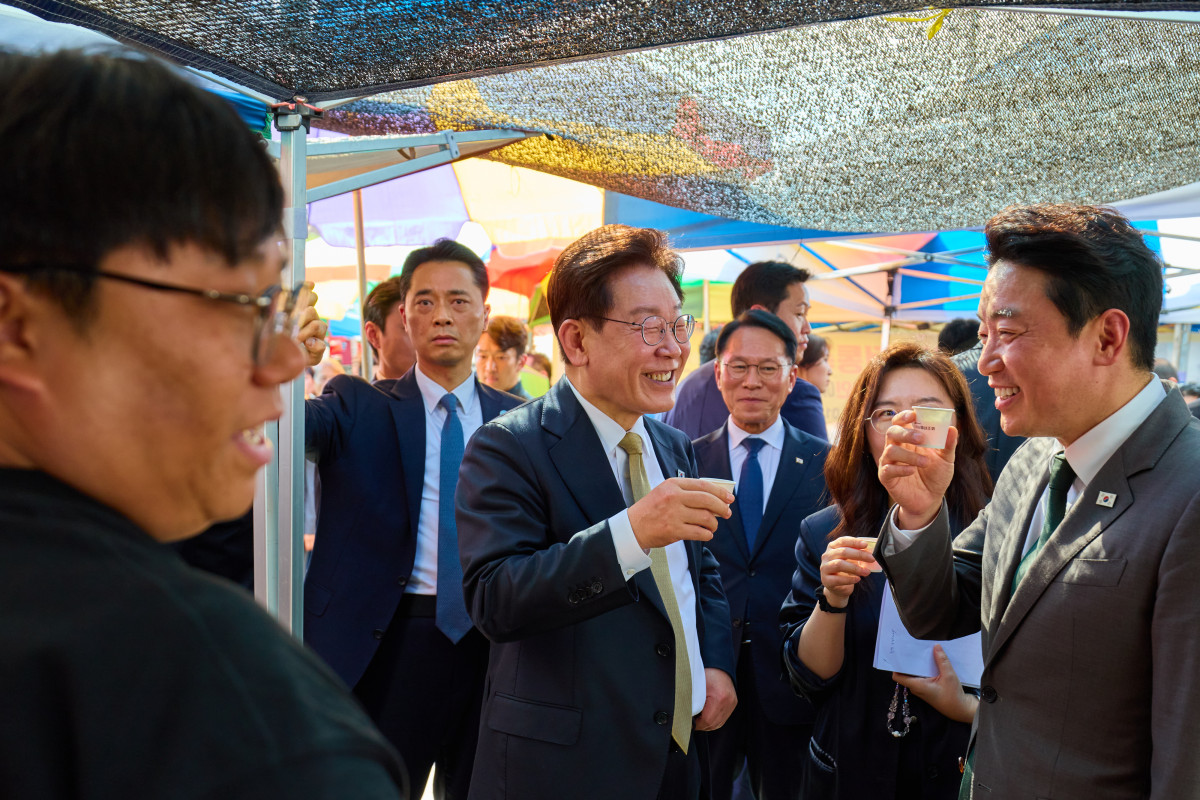 ▲이재명 대통령이 14일 성남 모란시장에서 강훈식 비서실장과 시식을 하며 대화하고 있다. (사진=연합뉴스)