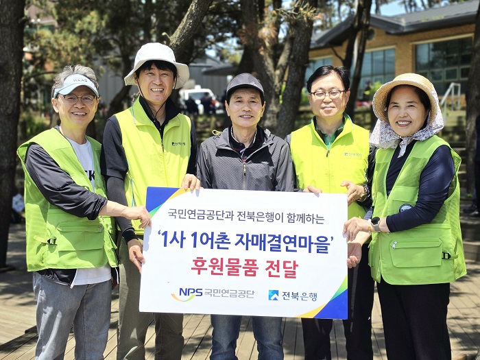 ▲전북은행지역사랑봉사단과 국민연금공단 관계자들이 15일 군산시 옥도면 방축도에서 ‘1사 1어촌 자매결연마을’ 후원 물품을 전달한 뒤 기념촬영을 하고 있다. (사진제공=전북은행)