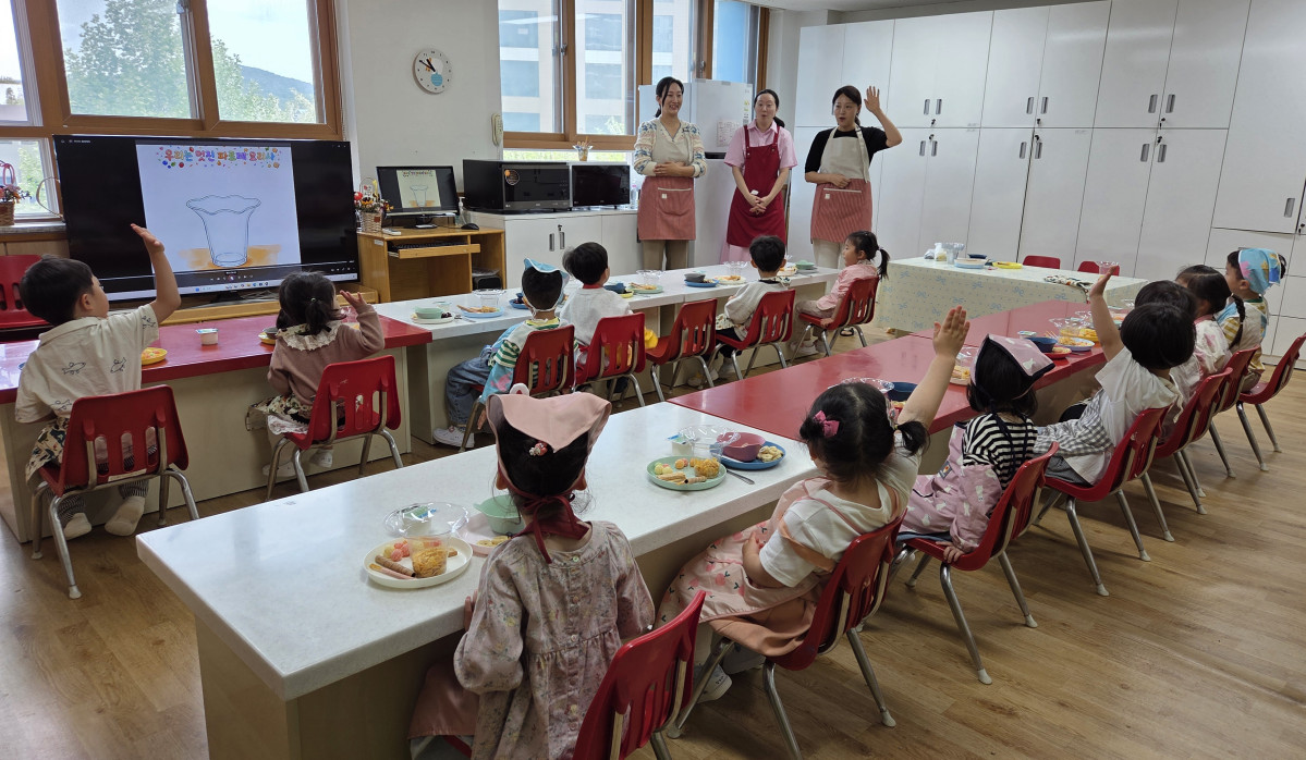 ▲한누리유치원 학부모들이 앞치마를 두르고 유아들에게 요리 활동을 지도하고 있다. 아이들이 손을 번쩍 들어 질문하며 수업에 빠져들고 있다. (한누리유치원)