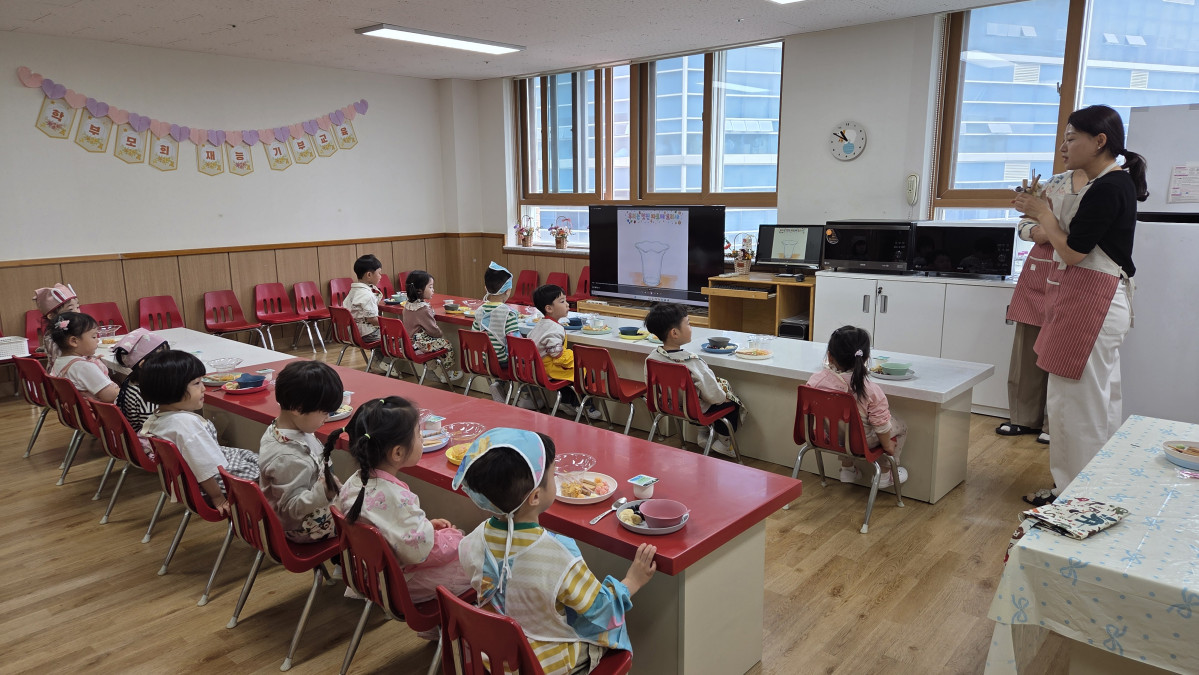 ▲한누리유치원 유아들이 학부모 재능기부 요리 수업에서 직접 만든 음식을 앞에 두고 학부모의 설명에 귀 기울이고 있다. (한누리유치원)