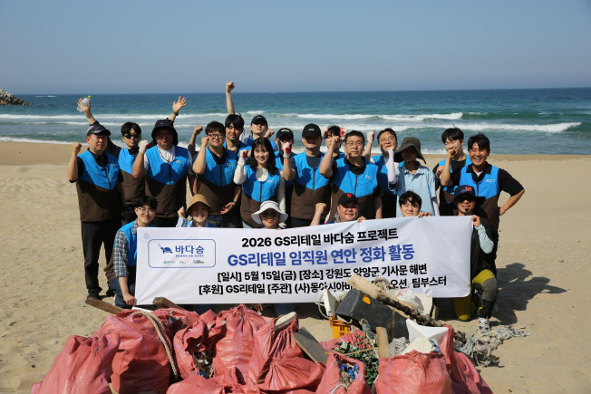 ▲GS리테일 임직원들과 해양NGO 오션 연구원들이 양양 기사문 해변 정화활동을 마친 후 수거한 쓰레기 앞에서 기념 촬영을 하고 있다. (사진제공=GS리테일)