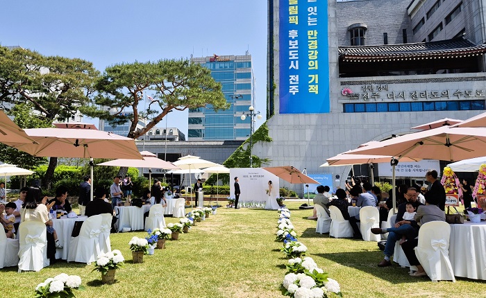 ▲전주시청 앞 노송광장 잔디광장이 청년 부부를 위한 무료 예식 공간으로 개방된 가운데, 많은 하객의 축하 속에서 야외 결혼식이 진행되고 있다. (사진제공=전주시)