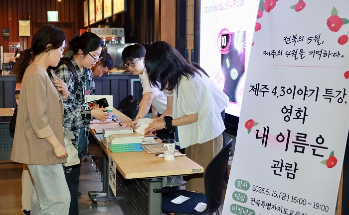 ▲전북특별자치도교육청 관계자 및 참가자들이 제주 4.3 특강과 영화 관람 행사에 참여하기 위해 접수를 진행하고 있다. (사진제공=전북특별자치도교육청)