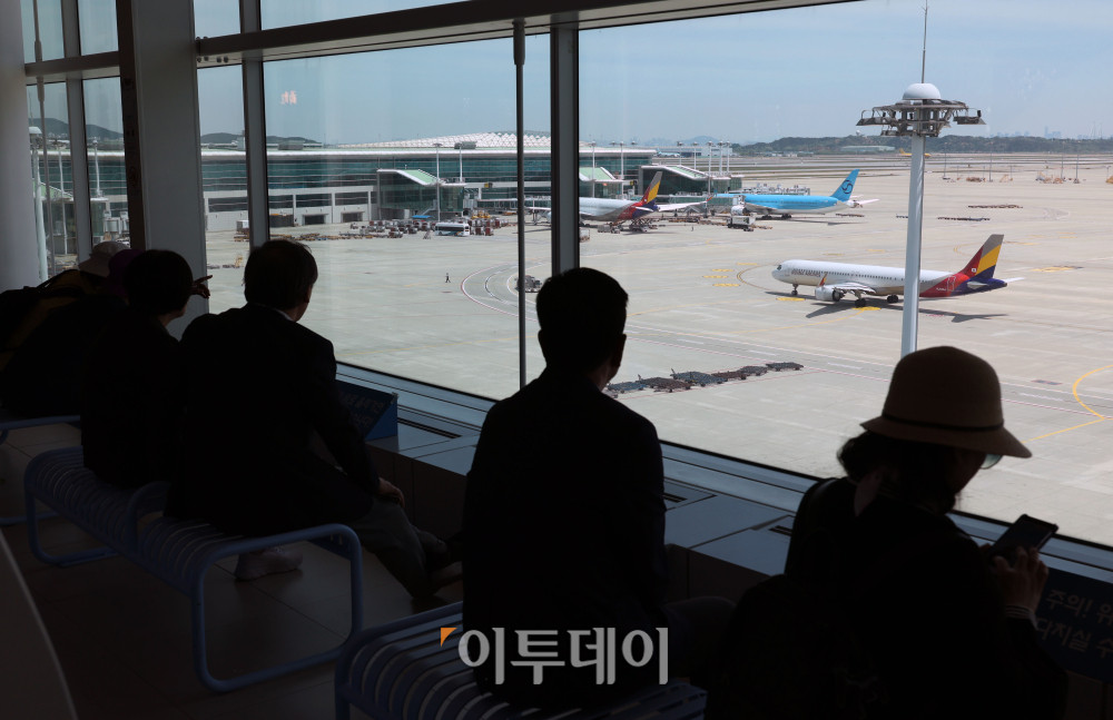 ▲중동발 지정학적 긴장 완화와 국제유가 안정세 영향으로 국제선 항공권 유류할증료가 다음 달부터 인하된다. 18일 관련 업계에 따르면 6월 국제선 항공권에는 유류할증료 27단계가 적용돼 이달보다 6단계 낮아진다. 대한항공 국제선 유류할증료도 편도 기준 최대 11만2500원 줄어들 전망이다. 이번 단계 조정에 따라 다른 국내 항공사들도 유류할증료를 순차적으로 조정할 것으로 보인다. 이날 인천국제공항 제2터미널 전망대에서 여행객들이 주기장을 바라보고 있다. 고이란 기자 photoeran@