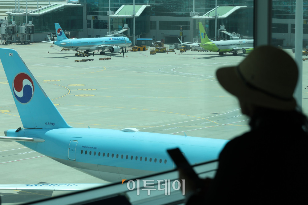 ▲중동발 지정학적 긴장 완화와 국제유가 안정세 영향으로 국제선 항공권 유류할증료가 다음 달부터 인하된다. 18일 관련 업계에 따르면 6월 국제선 항공권에는 유류할증료 27단계가 적용돼 이달보다 6단계 낮아진다. 대한항공 국제선 유류할증료도 편도 기준 최대 11만2500원 줄어들 전망이다. 이번 단계 조정에 따라 다른 국내 항공사들도 유류할증료를 순차적으로 조정할 것으로 보인다. 이날 인천국제공항 제2터미널 전망대에서 여행객들이 주기장을 바라보고 있다. 고이란 기자 photoeran@