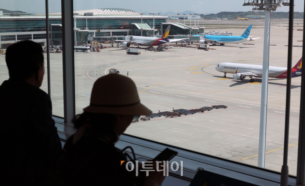 ▲중동발 지정학적 긴장 완화와 국제유가 안정세 영향으로 국제선 항공권 유류할증료가 다음 달부터 인하된다. 18일 관련 업계에 따르면 6월 국제선 항공권에는 유류할증료 27단계가 적용돼 이달보다 6단계 낮아진다. 대한항공 국제선 유류할증료도 편도 기준 최대 11만2500원 줄어들 전망이다. 이번 단계 조정에 따라 다른 국내 항공사들도 유류할증료를 순차적으로 조정할 것으로 보인다. 이날 인천국제공항 제2터미널 전망대에서 여행객들이 주기장을 바라보고 있다. 고이란 기자 photoeran@