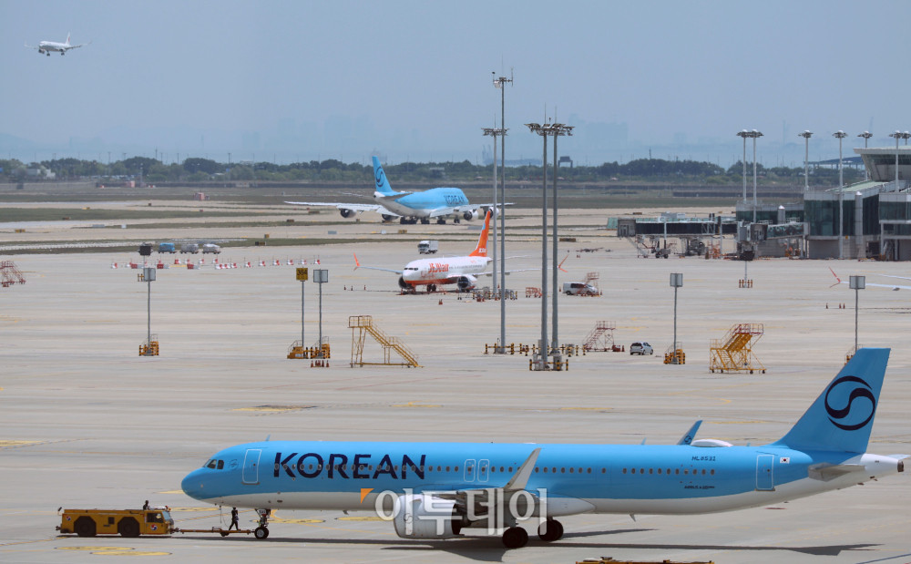 ▲중동발 지정학적 긴장 완화와 국제유가 안정세 영향으로 국제선 항공권 유류할증료가 다음 달부터 인하된다. 18일 관련 업계에 따르면 6월 국제선 항공권에는 유류할증료 27단계가 적용돼 이달보다 6단계 낮아진다. 대한항공 국제선 유류할증료도 편도 기준 최대 11만2500원 줄어들 전망이다. 이번 단계 조정에 따라 다른 국내 항공사들도 유류할증료를 순차적으로 조정할 것으로 보인다. 이날 인천국제공항 제2터미널 전망대에서 바라 본 주기장이 분주한 모습이다. 고이란 기자 photoeran@