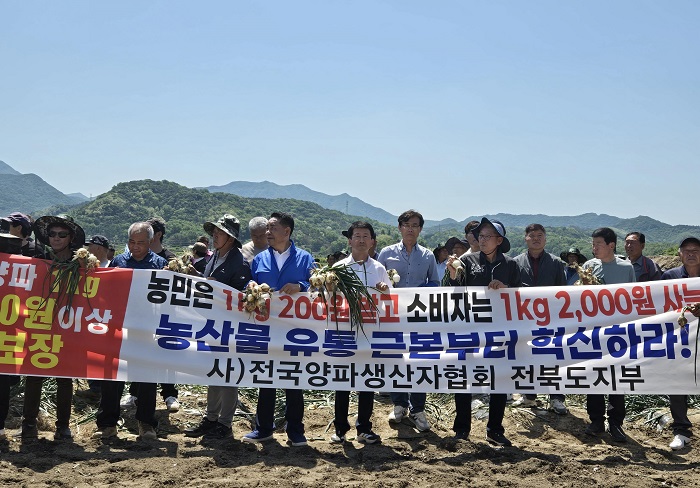▲권요안 전북특별자치도의원(왼쪽 네 번째)과 (사)전국양파생산자협회 전북도지부 관계자들이 완주군 고산면 양파밭에서 수확기 양파 가격 폭락에 대한 정부의 실효성 있는 대책 마련을 촉구하고 있다. (사진제공=전북특별자치도의회)