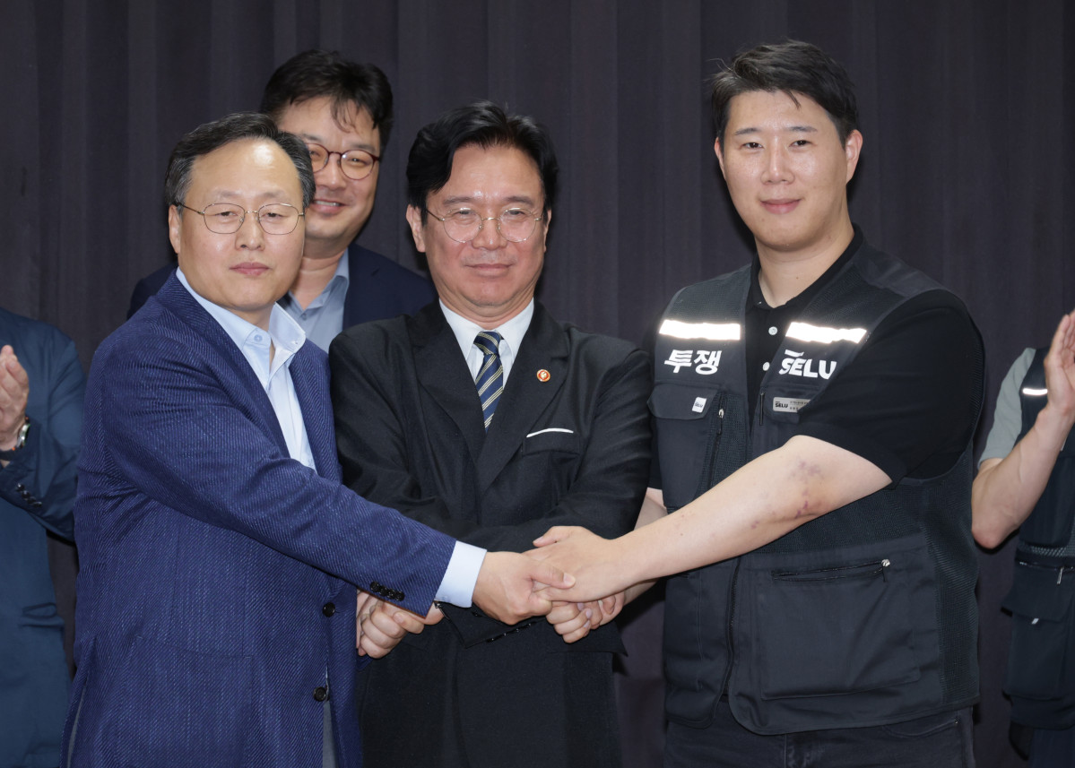 ▲20일 경기도 수원시 장안구 경기고용노동청에서 열린 삼성전자 임금협상을 마친 후 여명구 삼성전자 DS(디바이스솔루션·반도체 사업 담당) 피플팀장과 최승호 삼성그룹 초기업노동조합 삼성전자지부 위원장이 잠정 합의안에 서명한 후 김영환 고용노동부 장관과 손을 맞잡고 있다. (사진=연합뉴스)